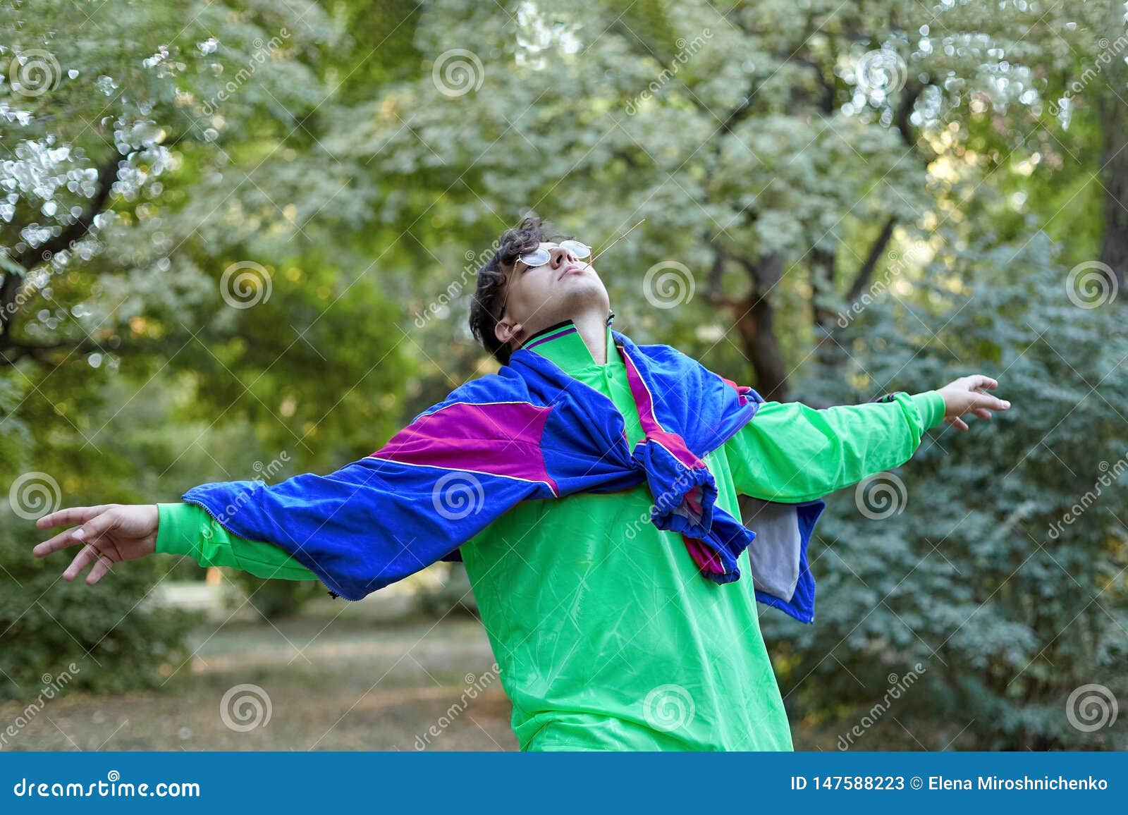 Young Handsome Caucasian Man with Bright Freaky Sportswear 70s Style Stands  at a Morning Park. Stick in the Mouth, Golden Glasses, Stock Image - Image  of attractive, nirvana: 147588223