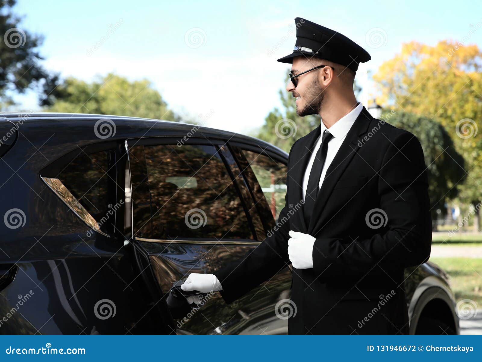 young handsome driver opening luxury car door