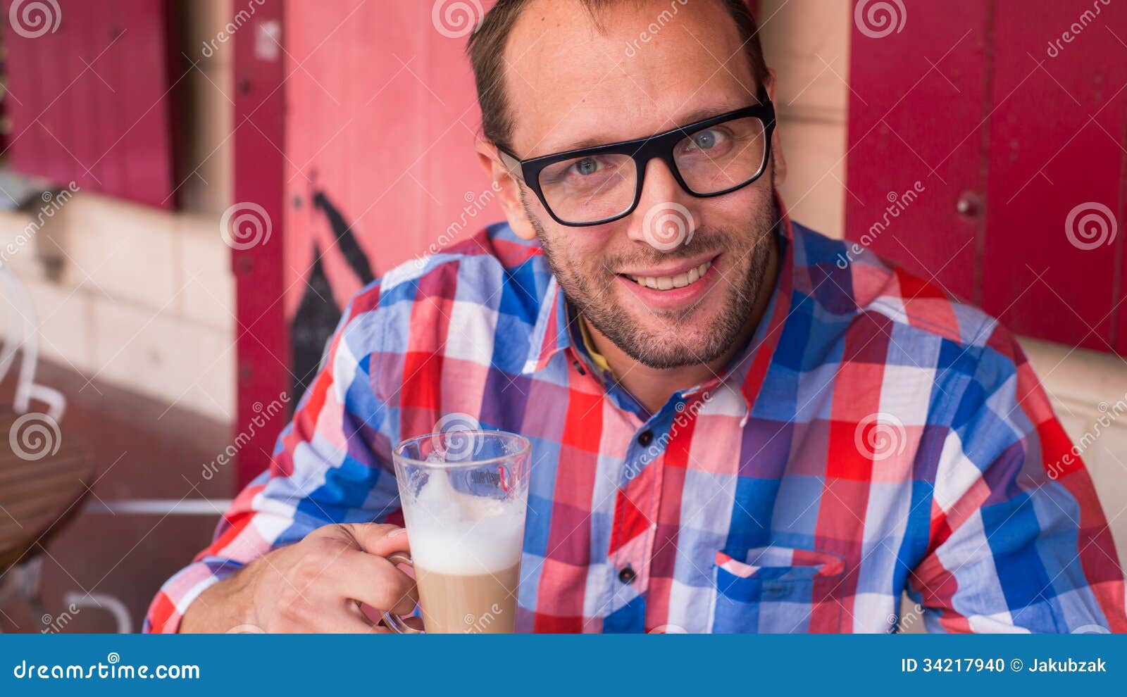 Young Handsome Man Drinking Coffee in a Cafe Indoors. Stock Photo