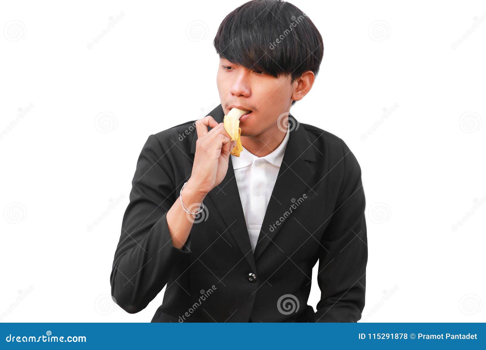 Young Handsome Man Eating A Banana On White Background Stock Photo