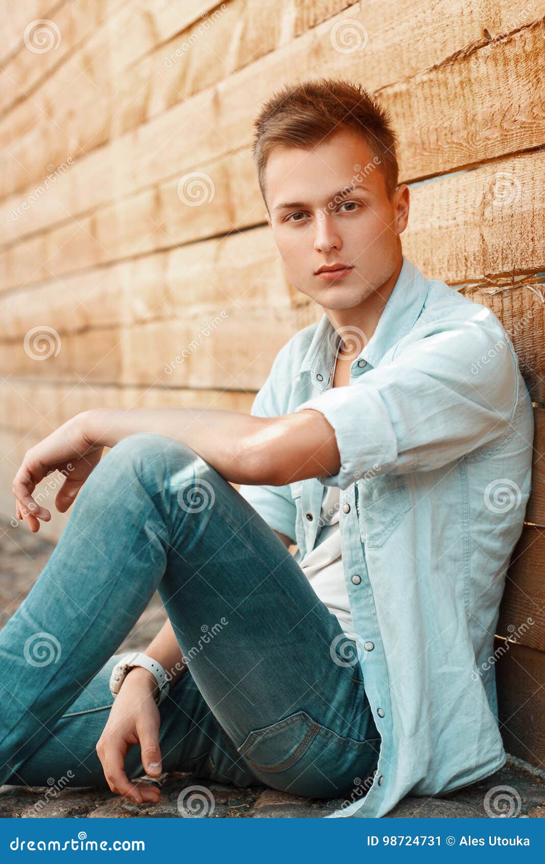 Young Handsome Man in Jeans Clothes Sitting Near a Wooden Wall. Stock ...