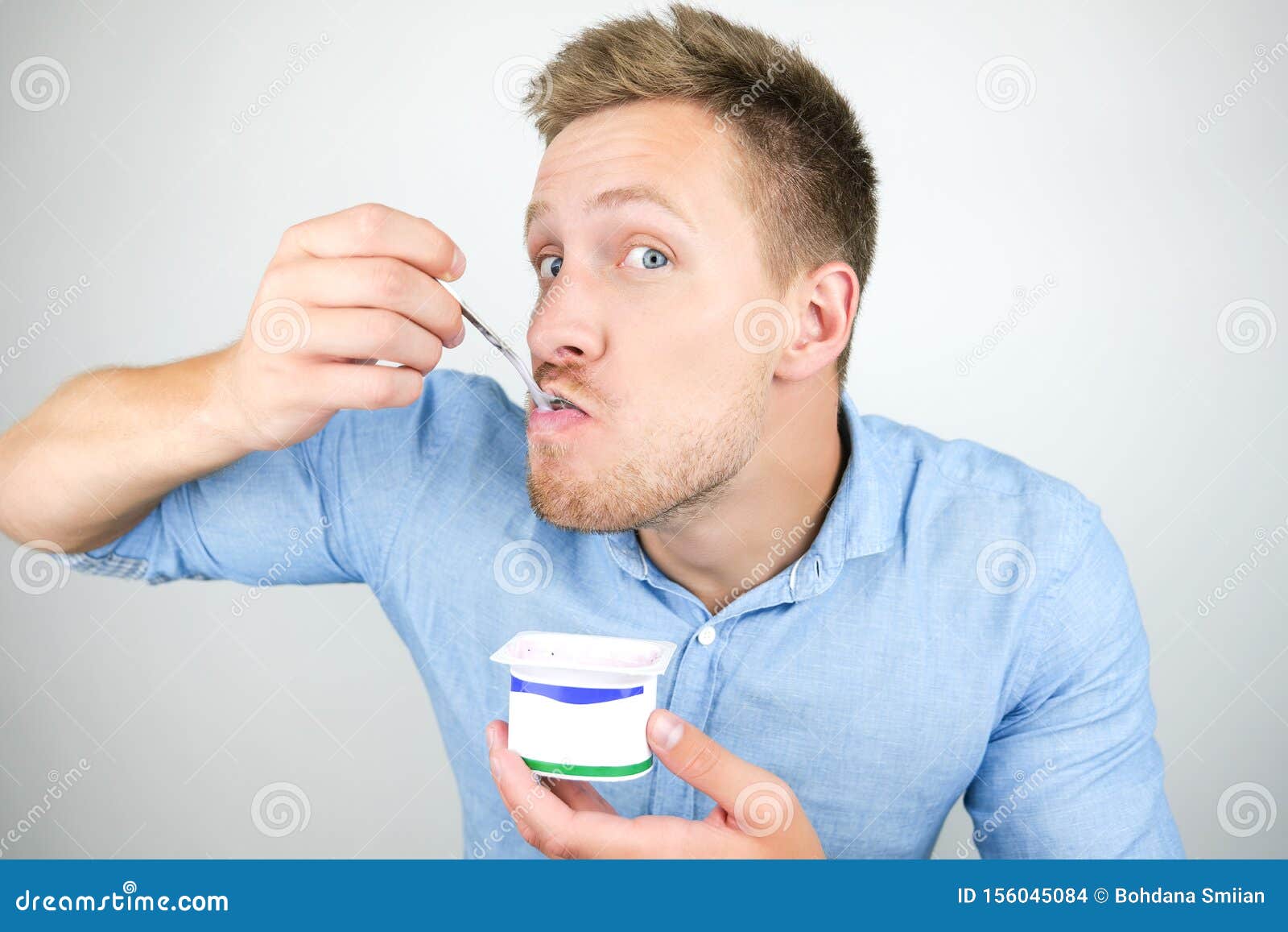 young-handsome-man-putting-spoon-yogurt-his-mouth-isolated-white-background-156045084.jpg