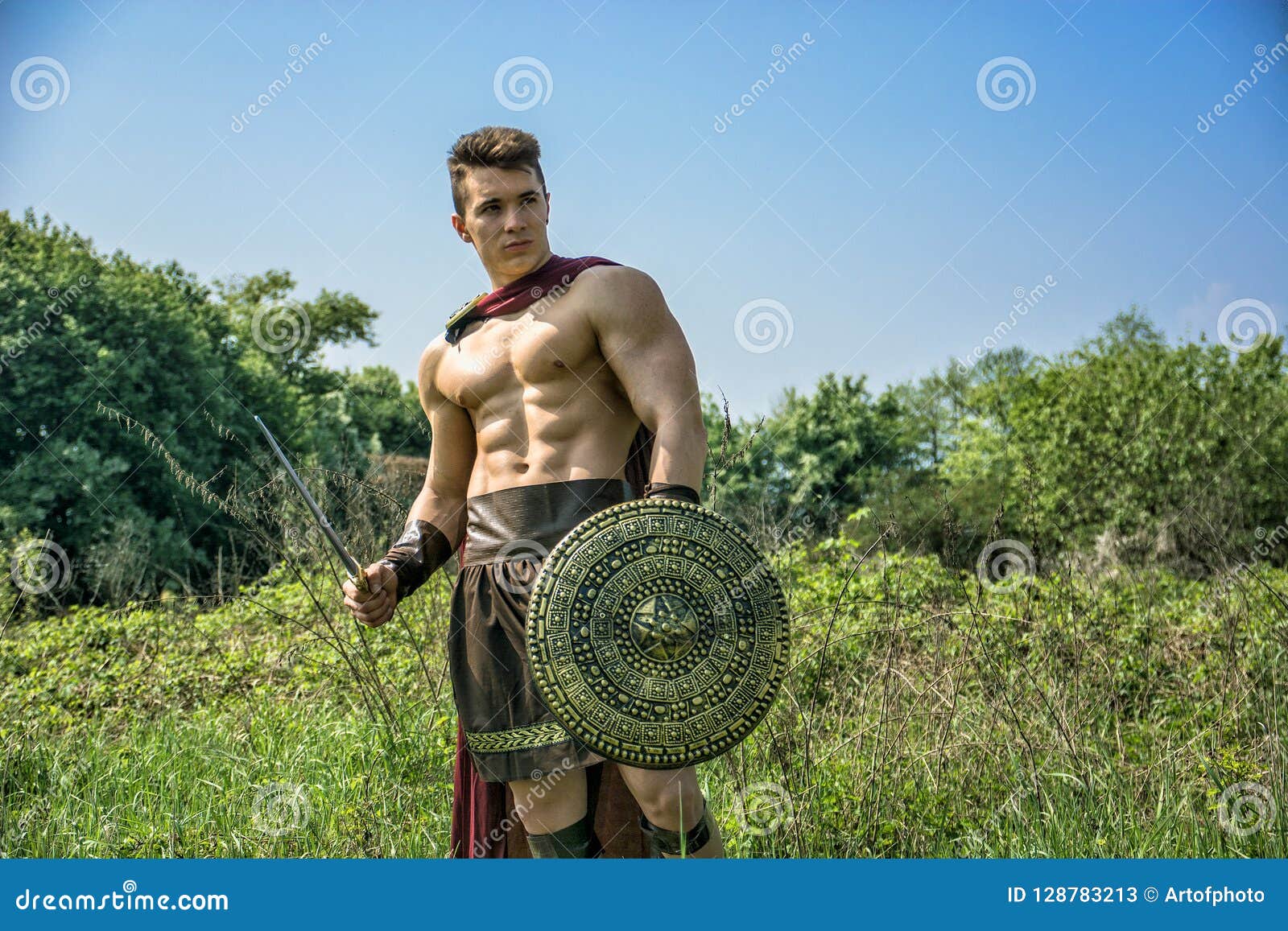 young muscular man posing in gladiator costume