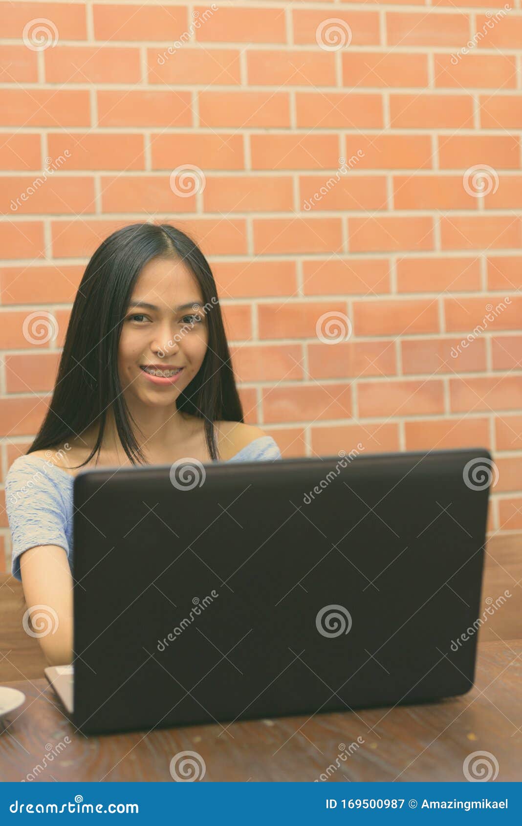 Young Beautiful Asian Teenage Girl Against Orange Wall 