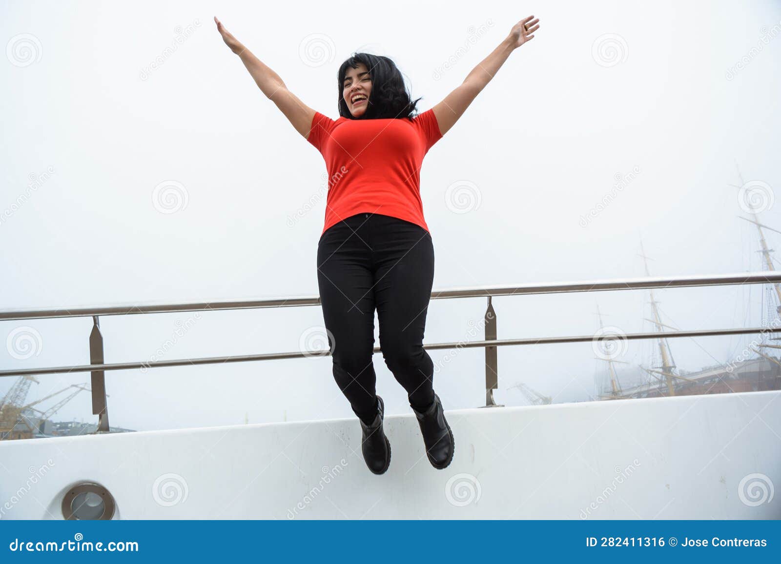 young happy latin woman tourist jumping on puente de la mujer in buenos aires