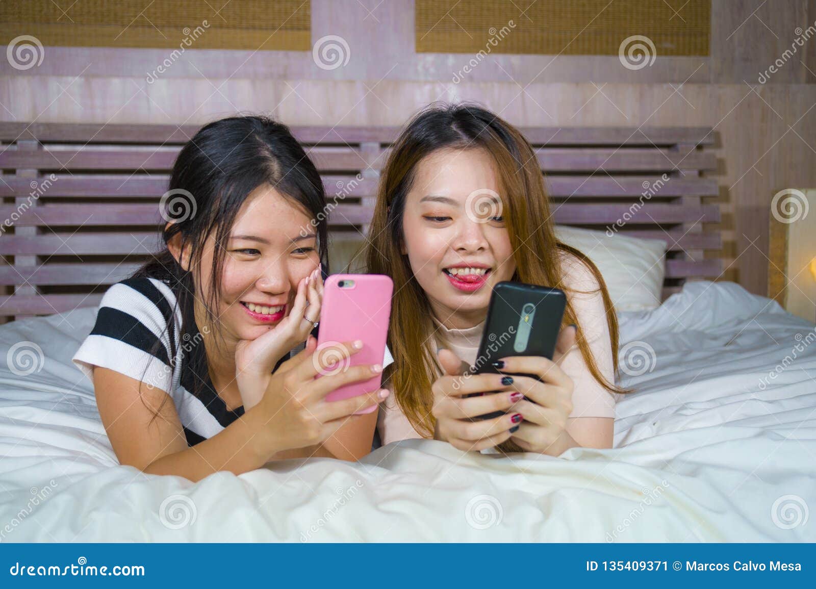 https://thumbs.dreamstime.com/z/young-happy-pretty-asian-chinese-girlfriends-sitting-home-bedroom-laughing-talking-having-fun-using-internet-social-two-135409371.jpg
