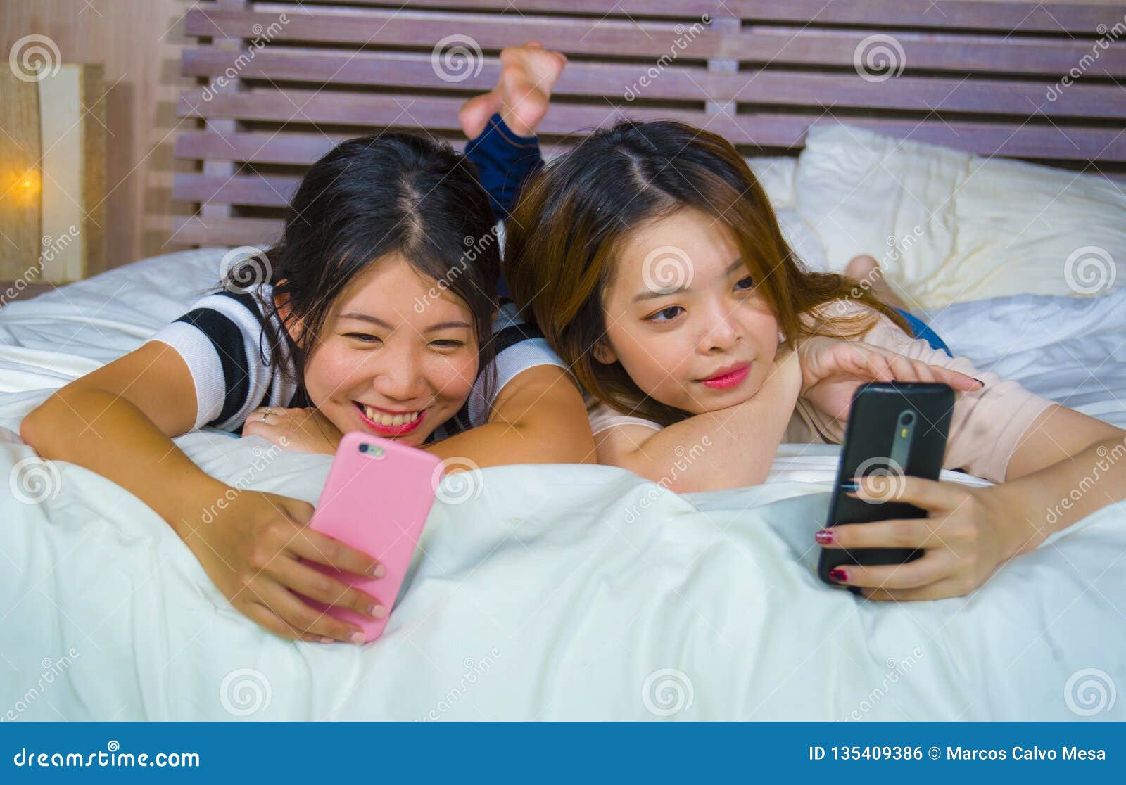 https://thumbs.dreamstime.com/z/young-happy-pretty-asian-chinese-girlfriends-sitting-home-bedroom-laughing-talking-having-fun-using-internet-social-two-135409386.jpg