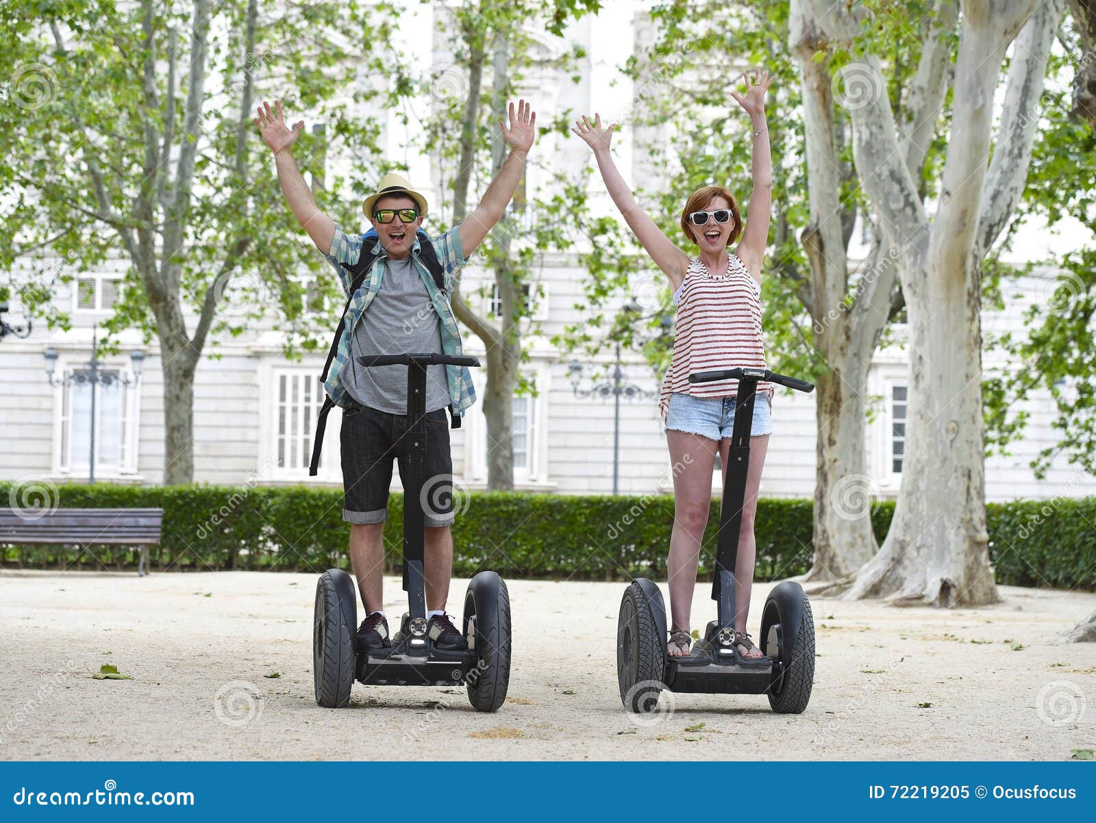 young happy tourist couple riding segway enjoying city tour in madrid park in spain together