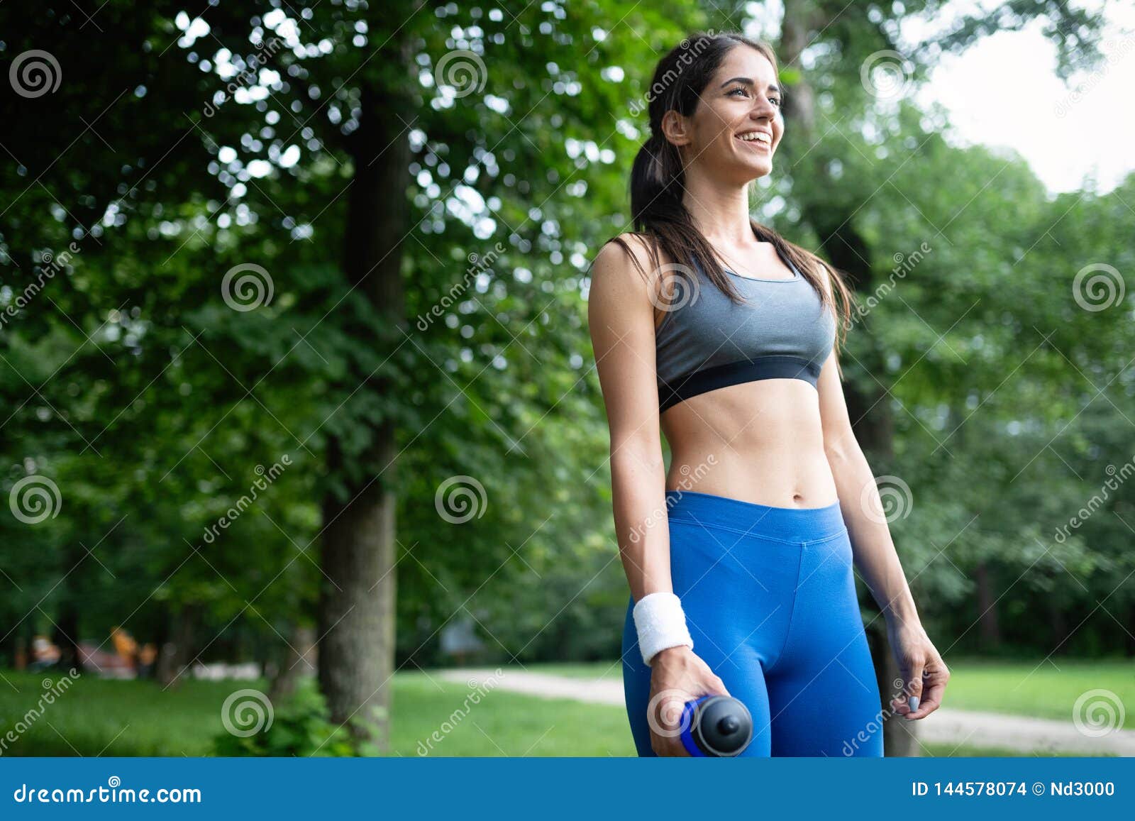 Happy Young Woman Doing Excercise Outdoor in a Park, Jogging Stock ...