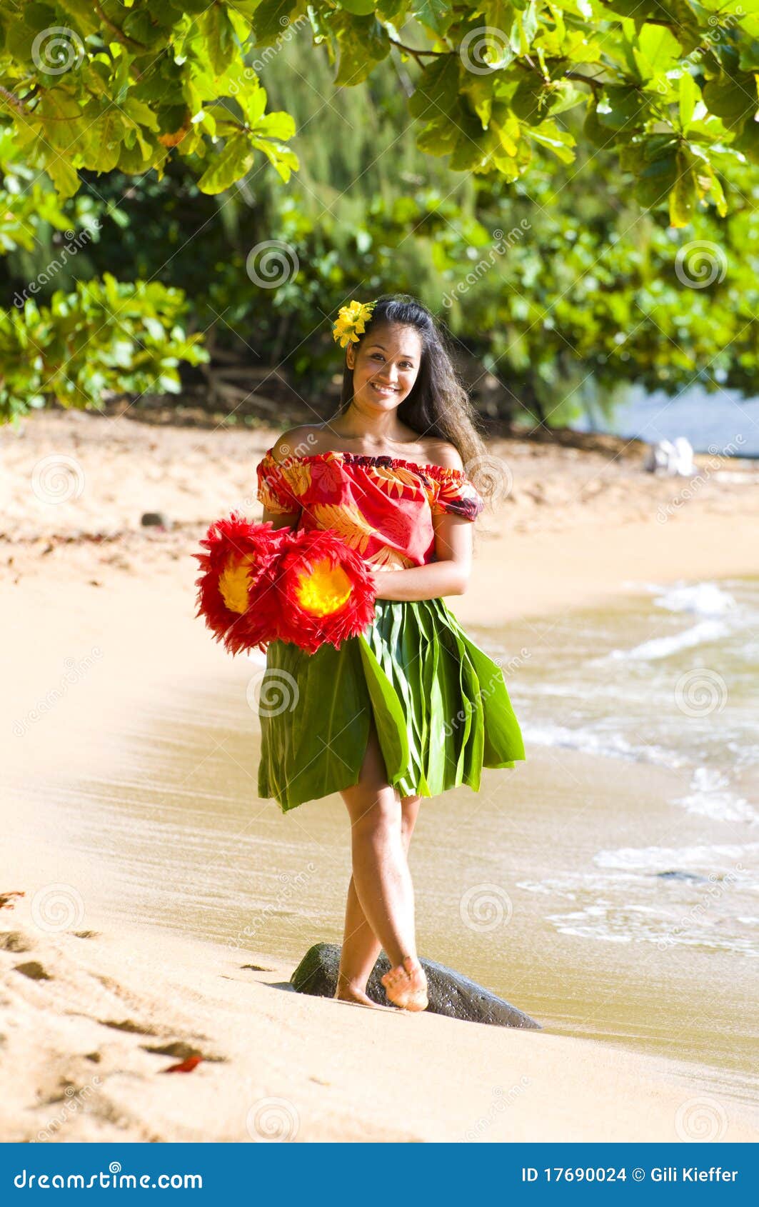 Hawaiian teenage girl in a traditional hula costume walking on the