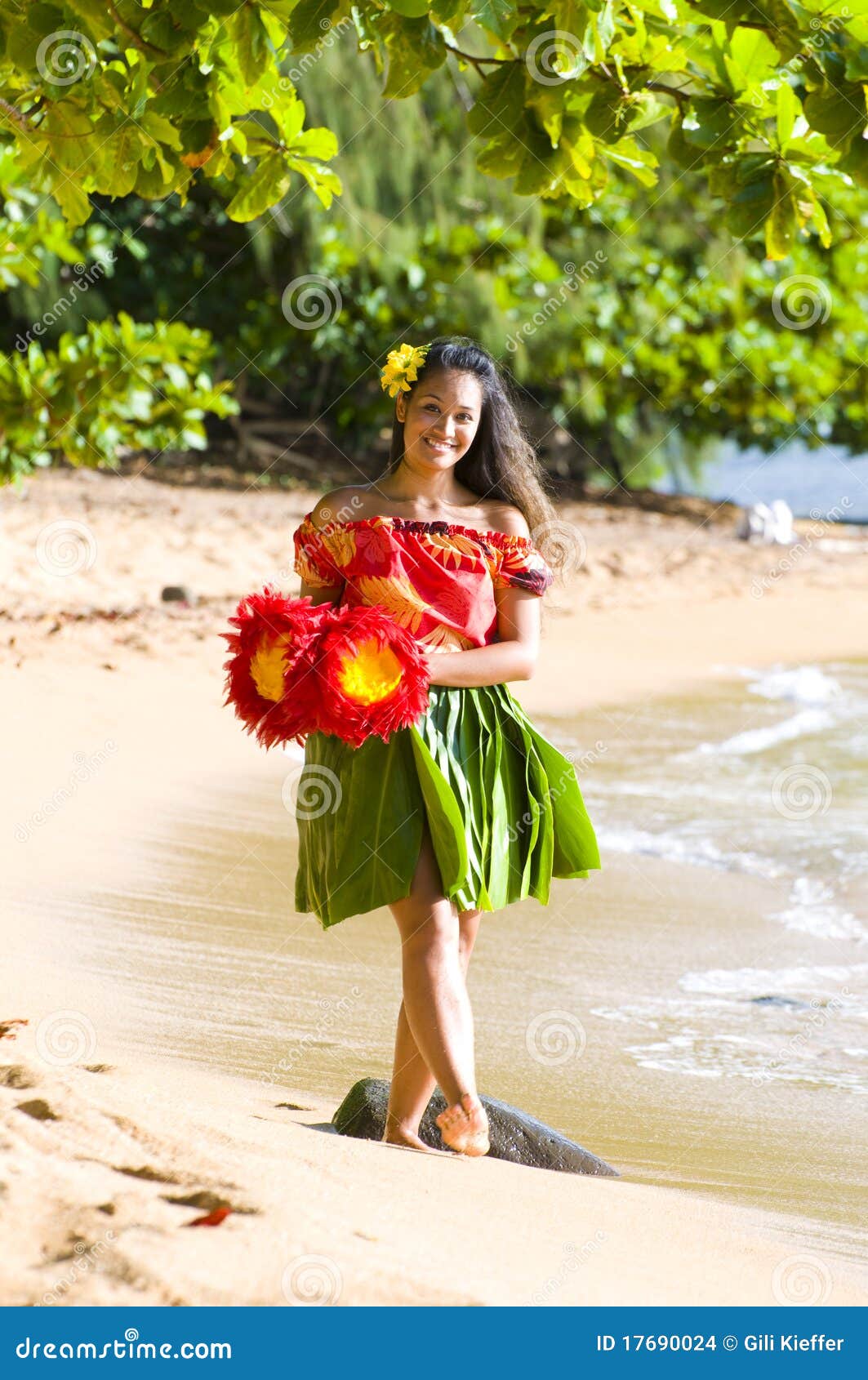 Hawaiian teenage girl in a traditional hula costume walking on the 