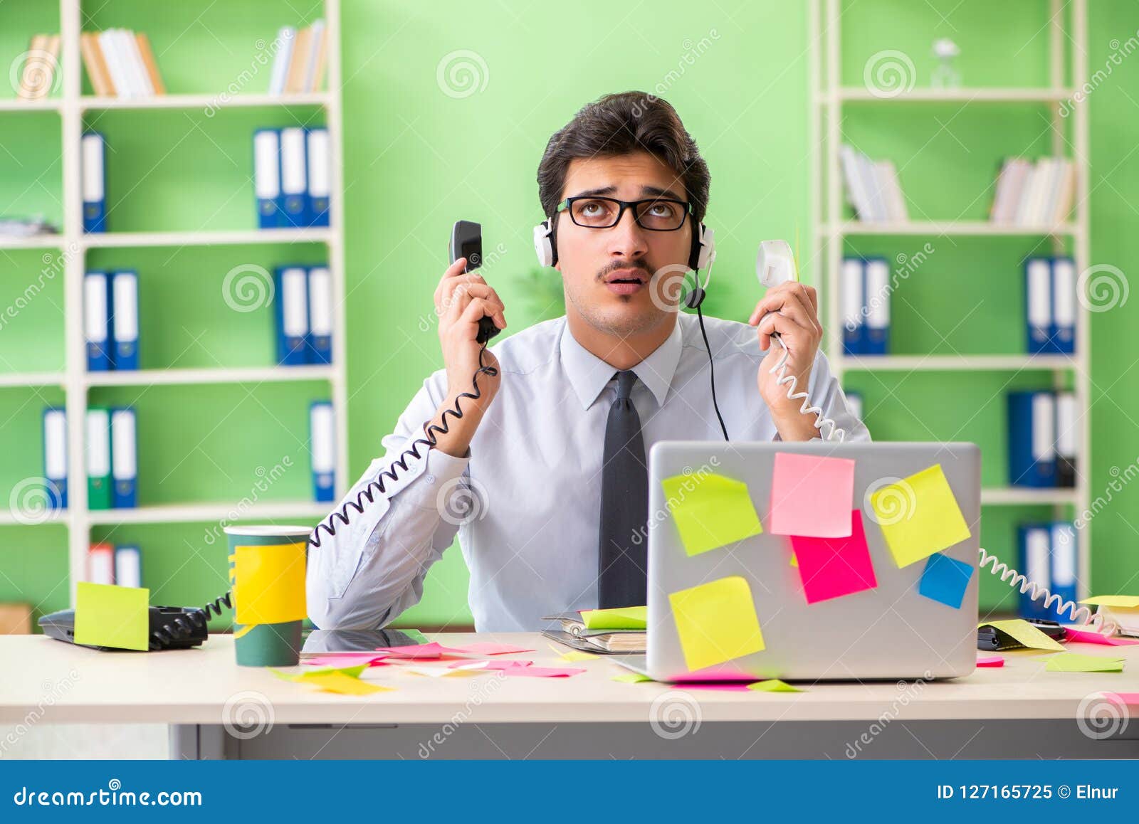 Young Help Desk Operator Working In Office With Many Conflicting