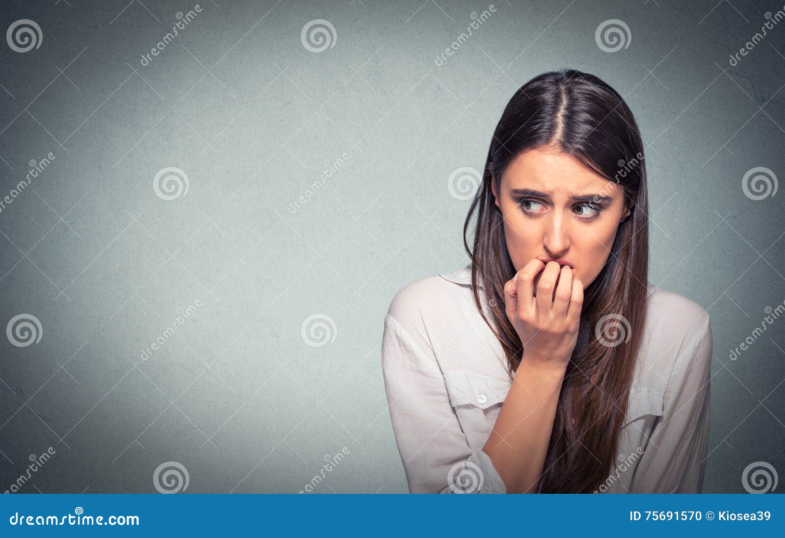 young hesitant nervous woman biting fingernails craving or anxious