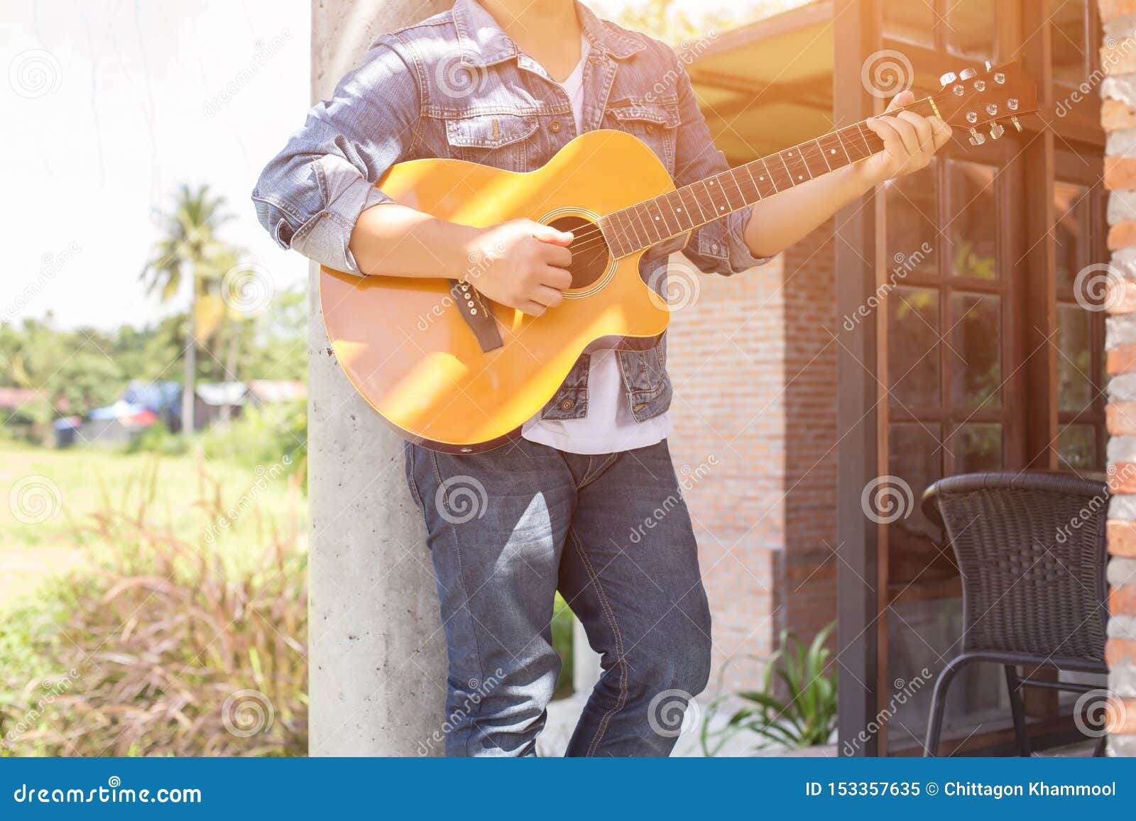 young hipster man practiced guitar in the park,happy and enjoy playing guitar.