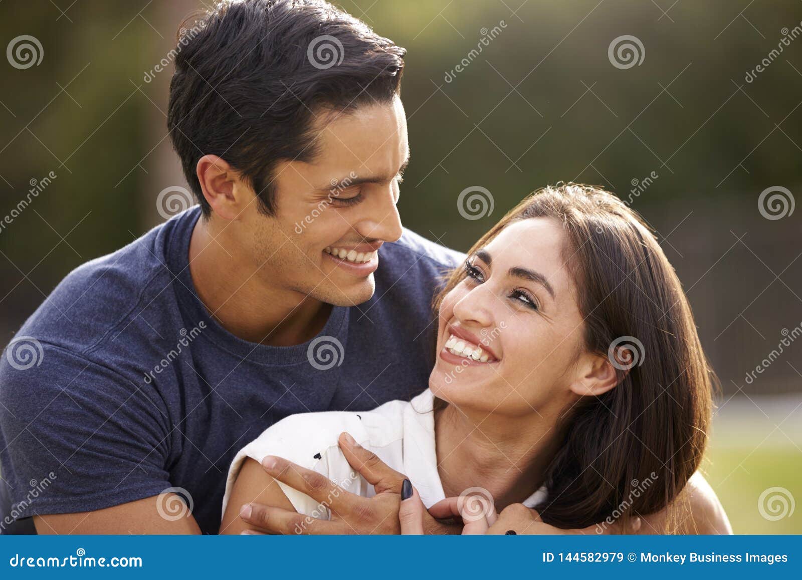 Young Hispanic Couple Looking At Each Other Smiling Close Up Stock