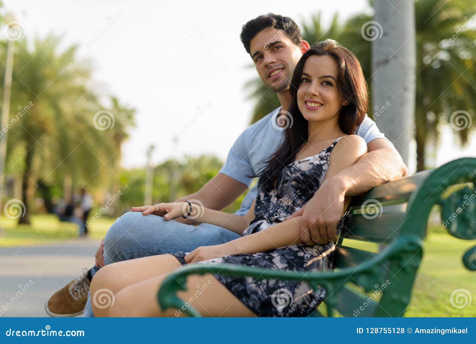 Young Hispanic Couple Relaxing In The Park Together Stock Photo Image