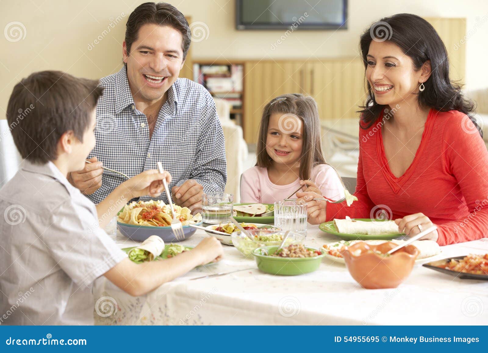 young hispanic family enjoying meal at home