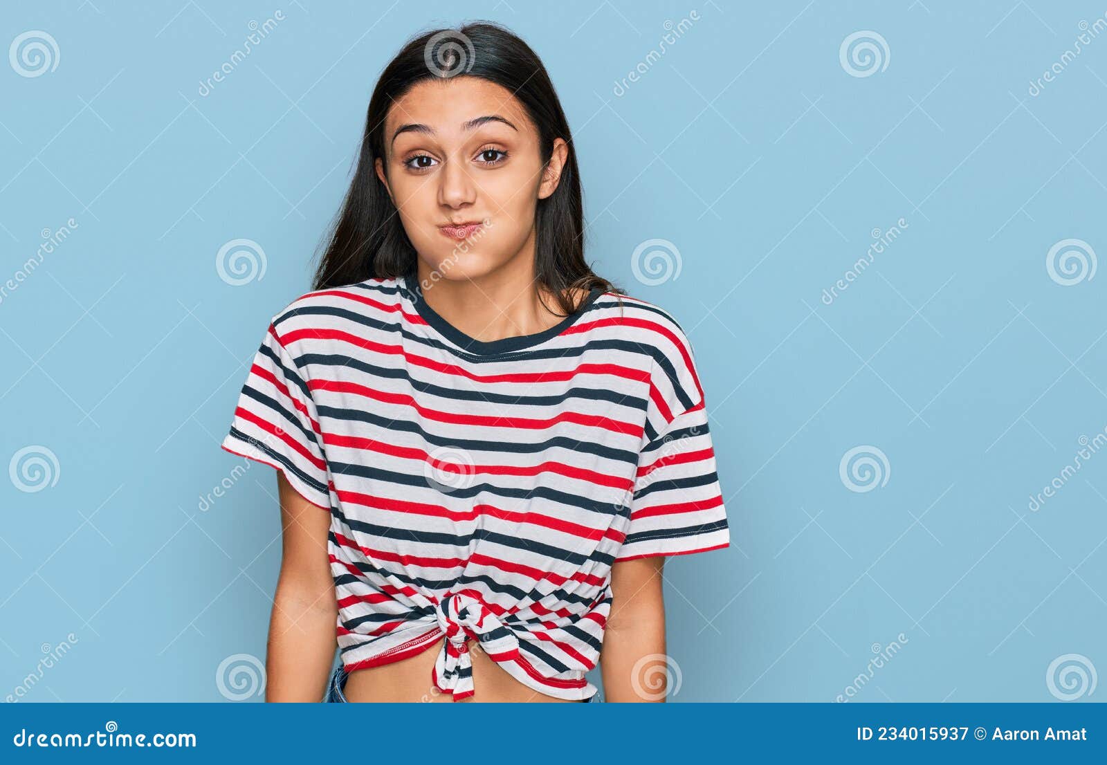 Young Hispanic Girl Wearing Casual Clothes Puffing Cheeks With Funny