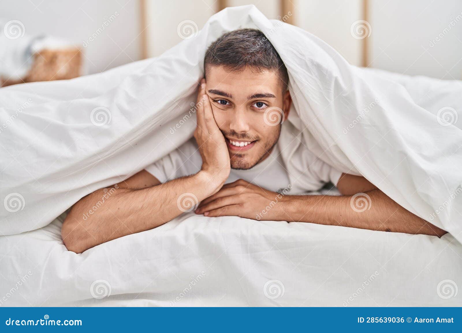 Young Hispanic Man Covering with Sheet Lying on Bed at Bedroom Stock ...