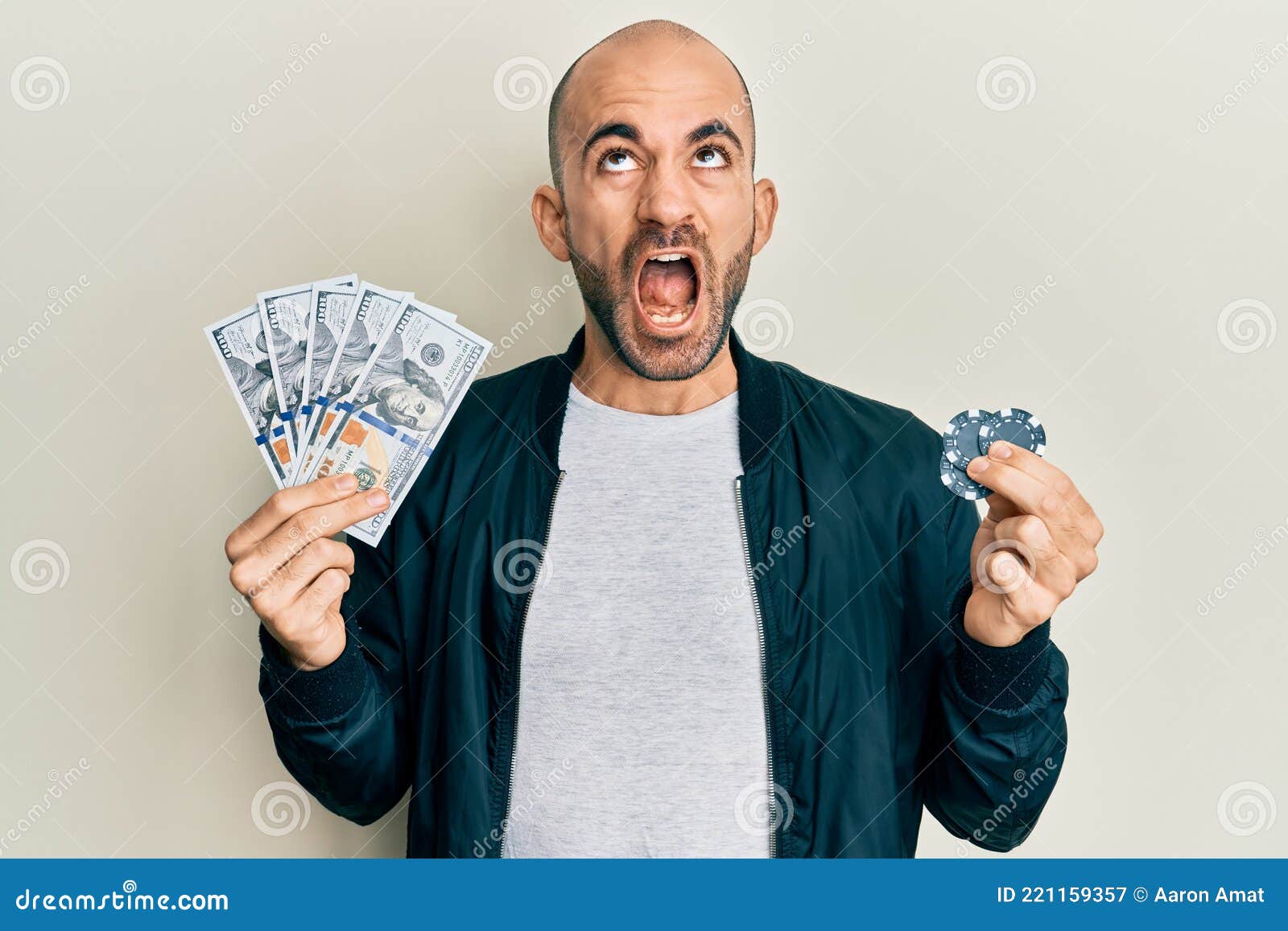 Young Hispanic Man Playing Poker Holding Dollars Banknotes and Chips ...