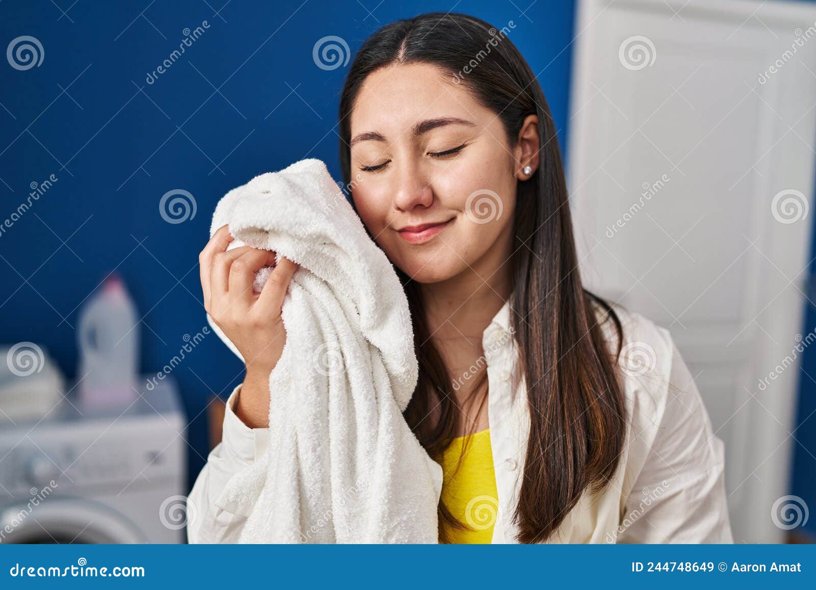 Young Hispanic Woman Touching Face with Soft Towel at Laundry Room ...