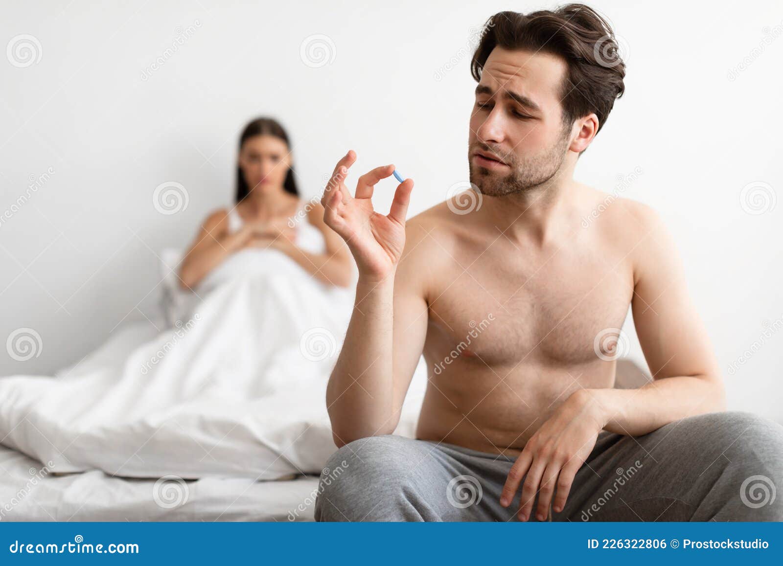 Young Husband Holding Potency Pill before Sex Indoors Stock Photo picture