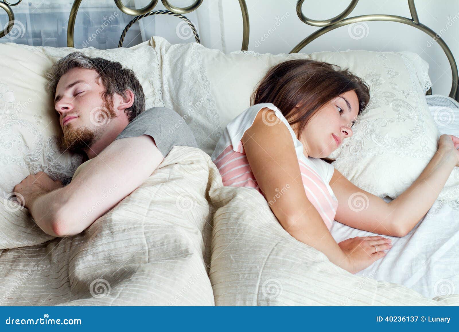 Young Husband And Wife Sleeping On The Bed In Bedroom Stock Photo