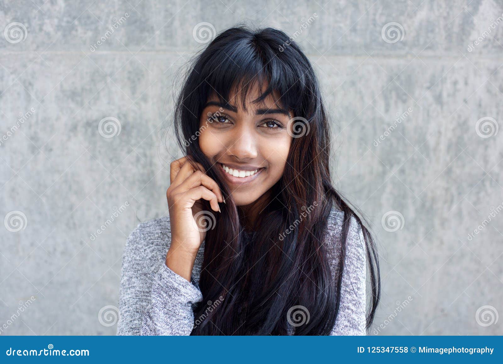 Young Indian Woman Smiling with Hand in Hair Stock Photo - Image of indian,  hand: 125347558