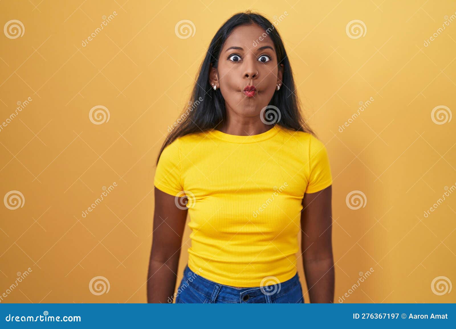 Young Indian Woman Standing Over Yellow Background Making Fish