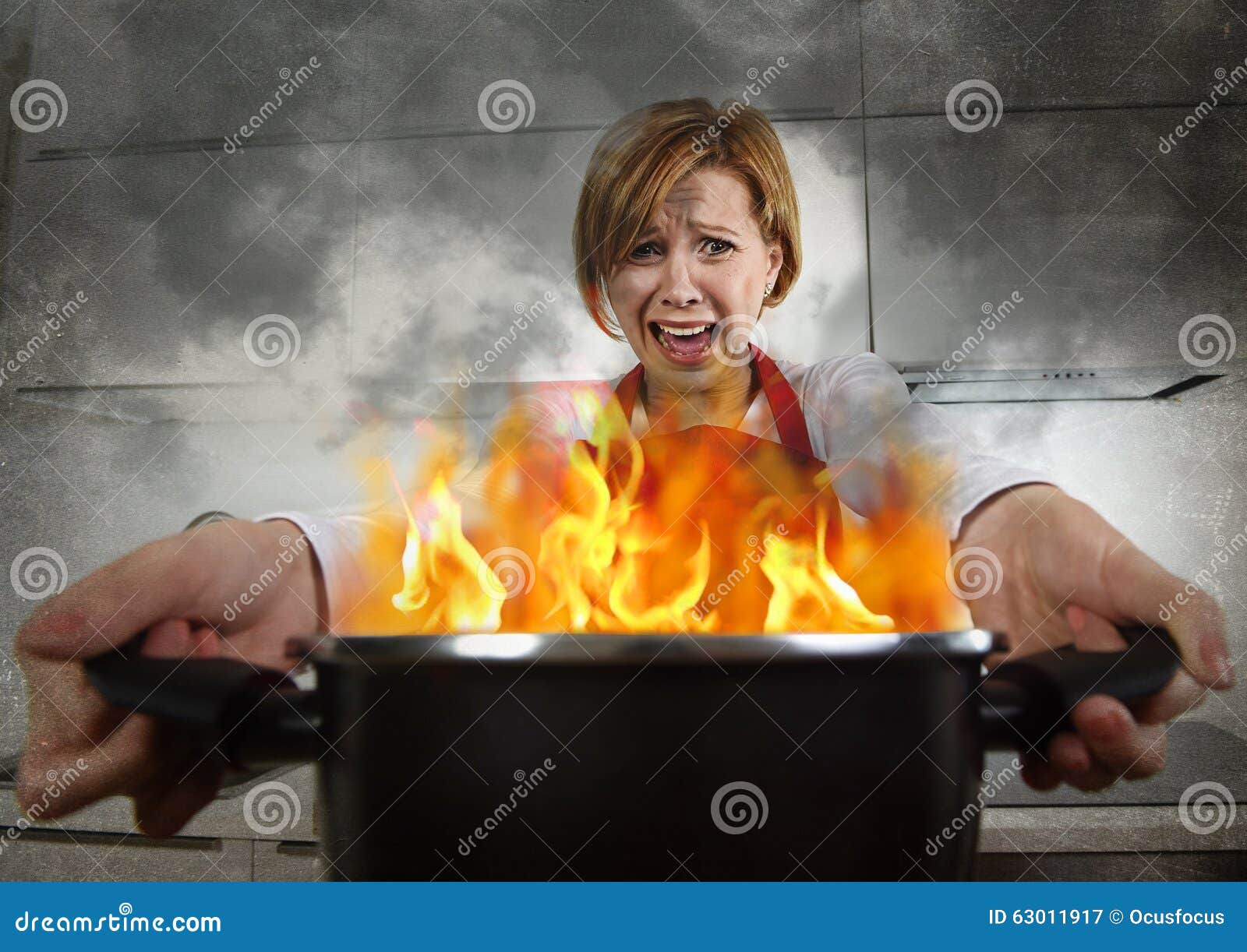 young inexperienced home cook woman in panic with apron holding pot burning in flames with in panic
