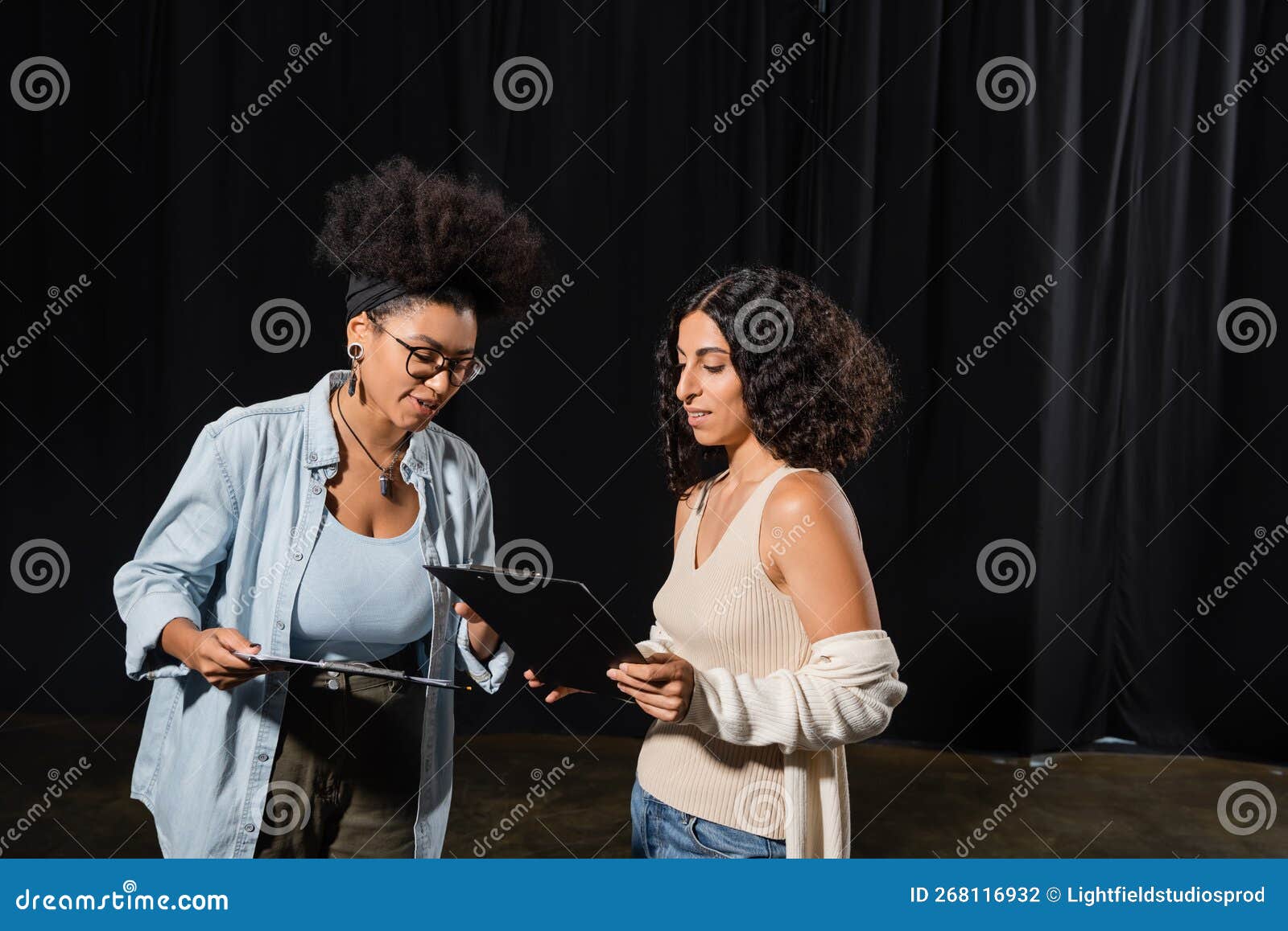 young interracial actresses looking at clipboards