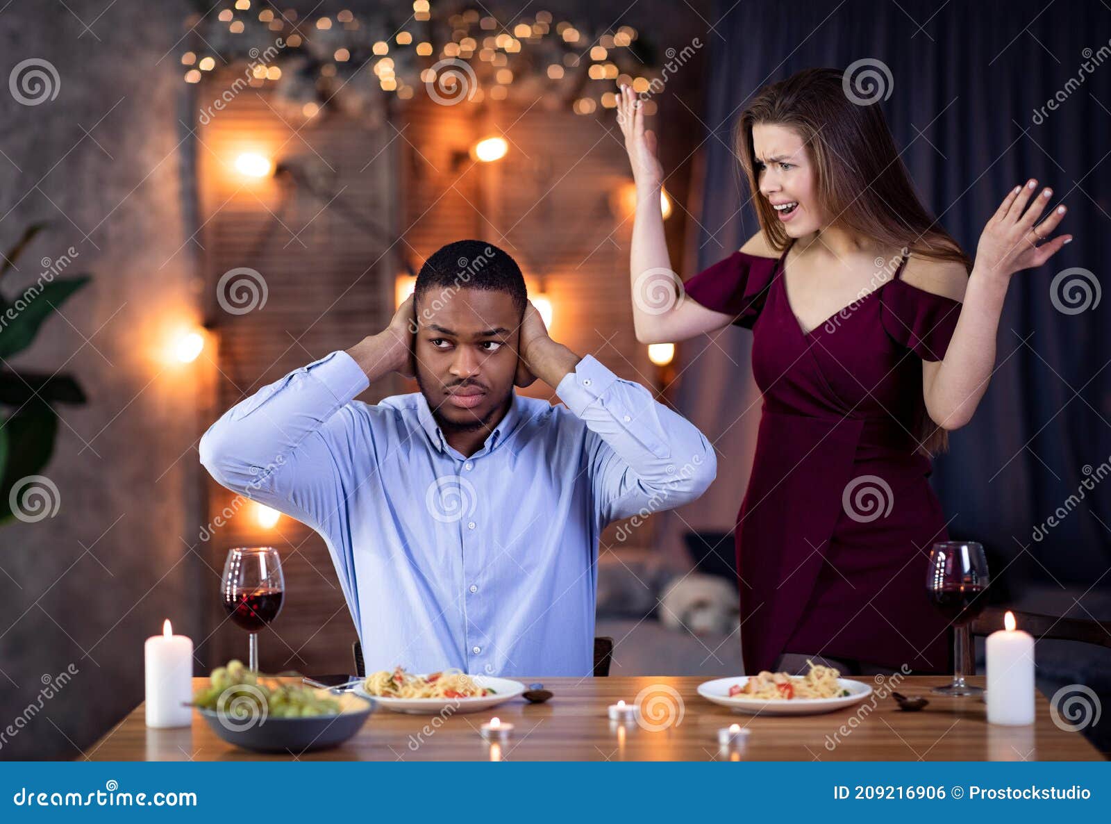 young interracial couple arguing during dinner date in restaurant
