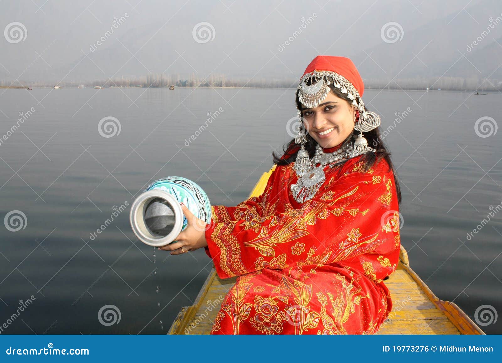 young kashmir girl collecting water from dal lake