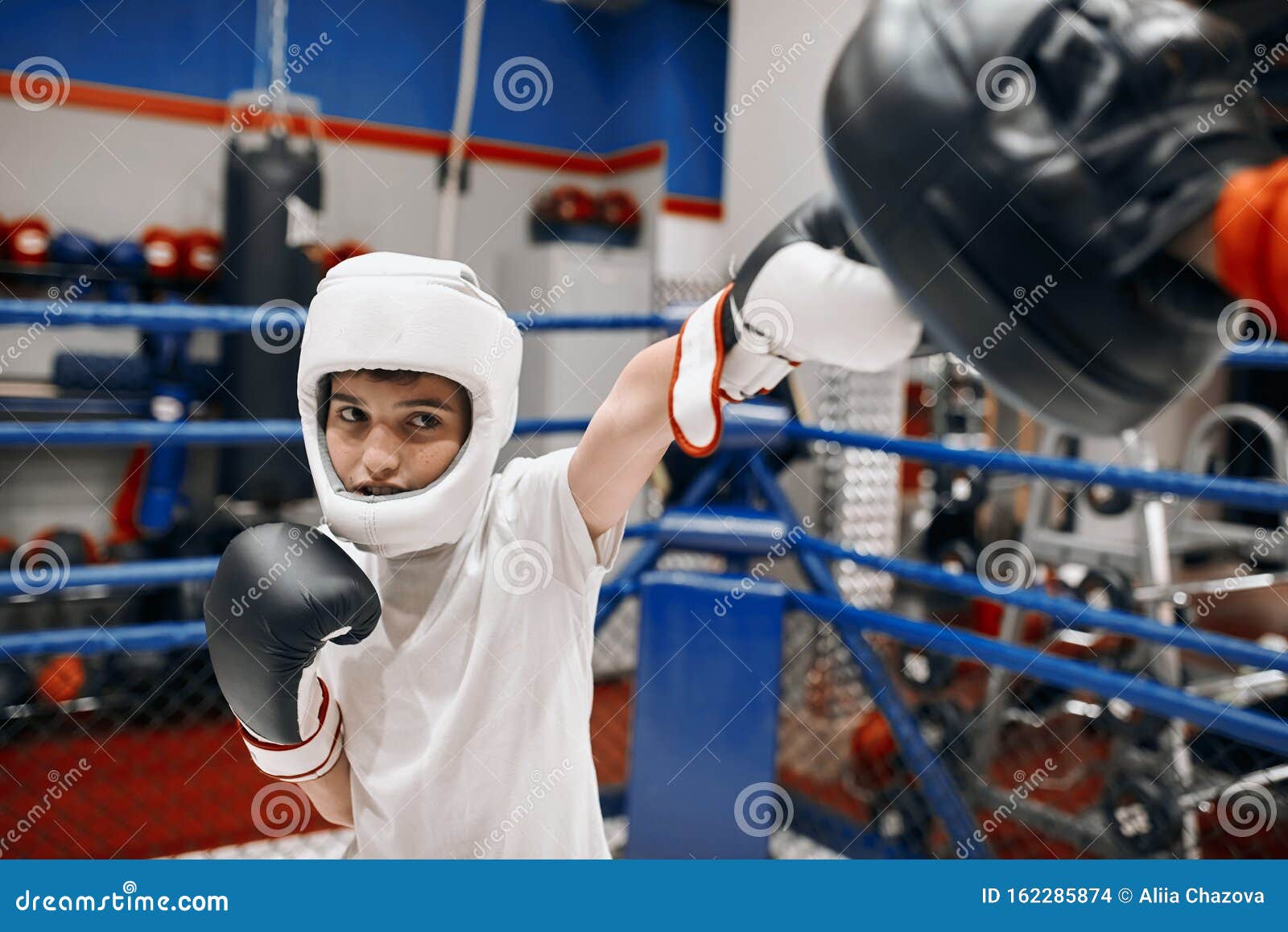 Young Kickboxer Developing Accuracy while Hitting the Coach Stock Photo
