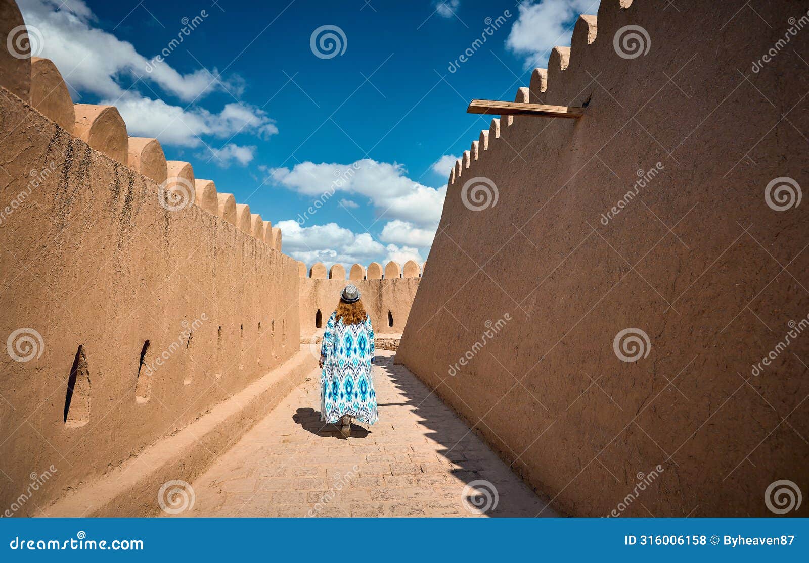 tourist in ethnic dress at city walls ichan kala of khiva