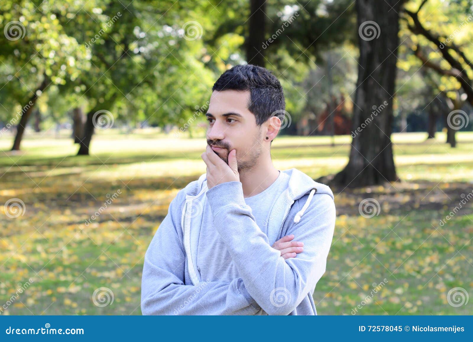 young latin man thoughtful in a park.