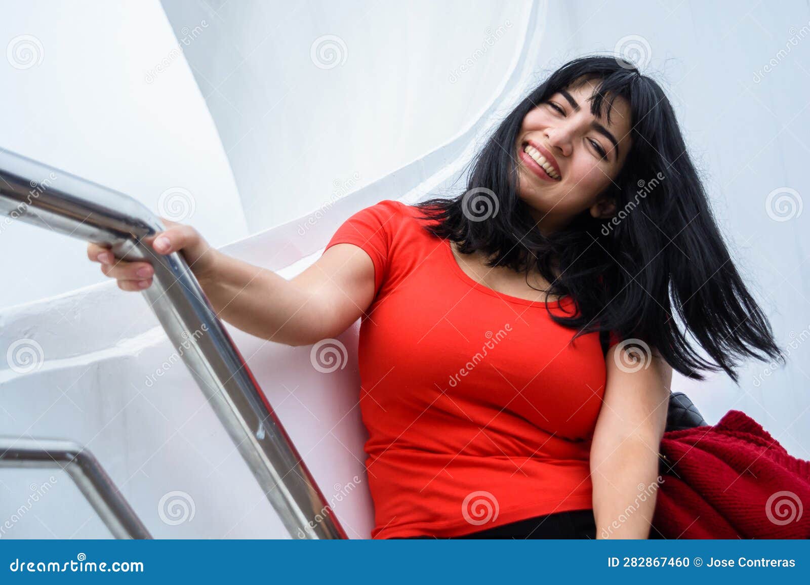 young latin woman sitting on puente de la mujer in buenos aires, smiling enjoying the vacation day