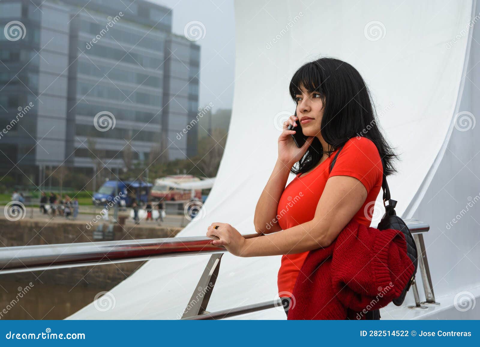 young latin woman standing on puente de la mujer in buenos aires worried on a phone call listening