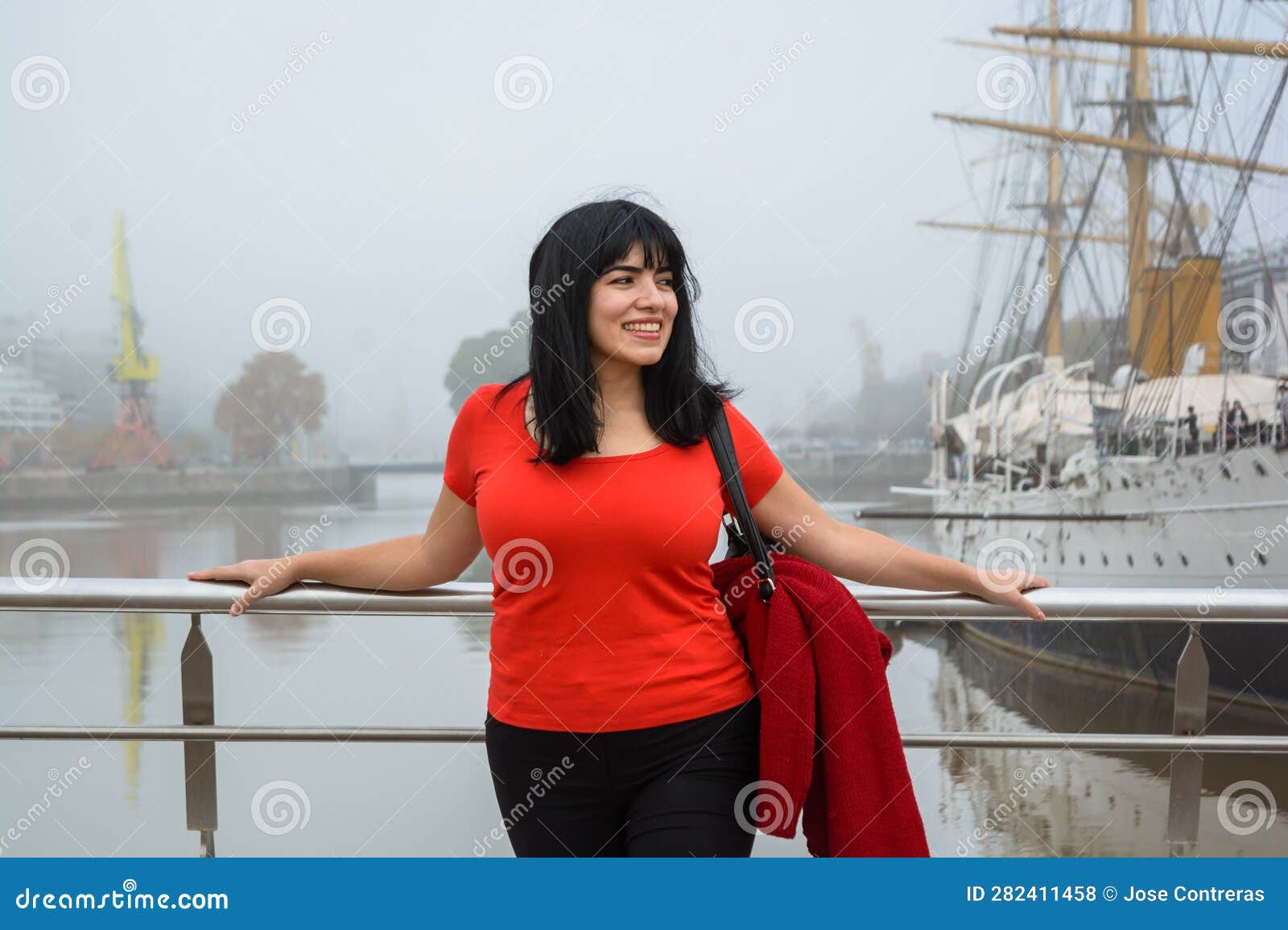 young latin woman tourist standing on the puente de la mujer in buenos aires looking to the side