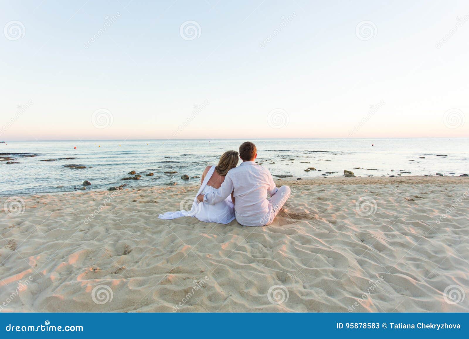 Young Love Couple Sitting Together on Beach, Rear View Stock Image