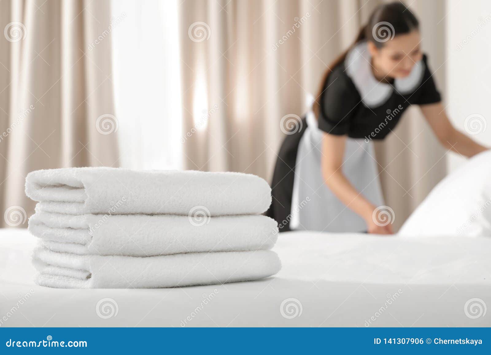 Young Maid Making Bed in Hotel Room, Focus on Stack Stock Photo Image