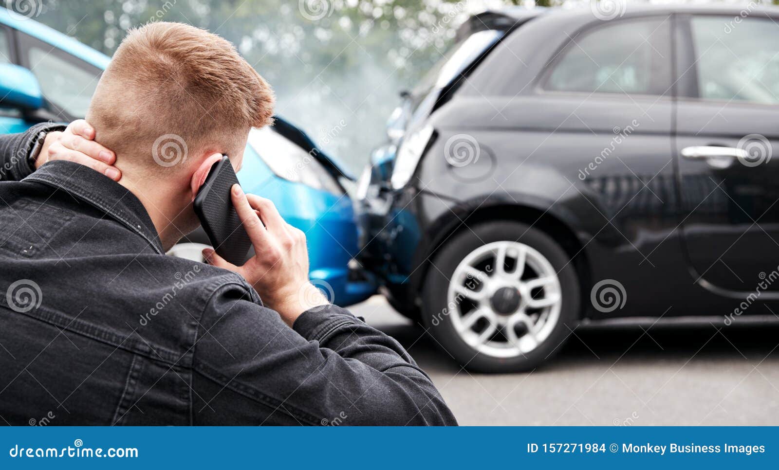 young male motorist involved in car accident calling insurance company or recovery service
