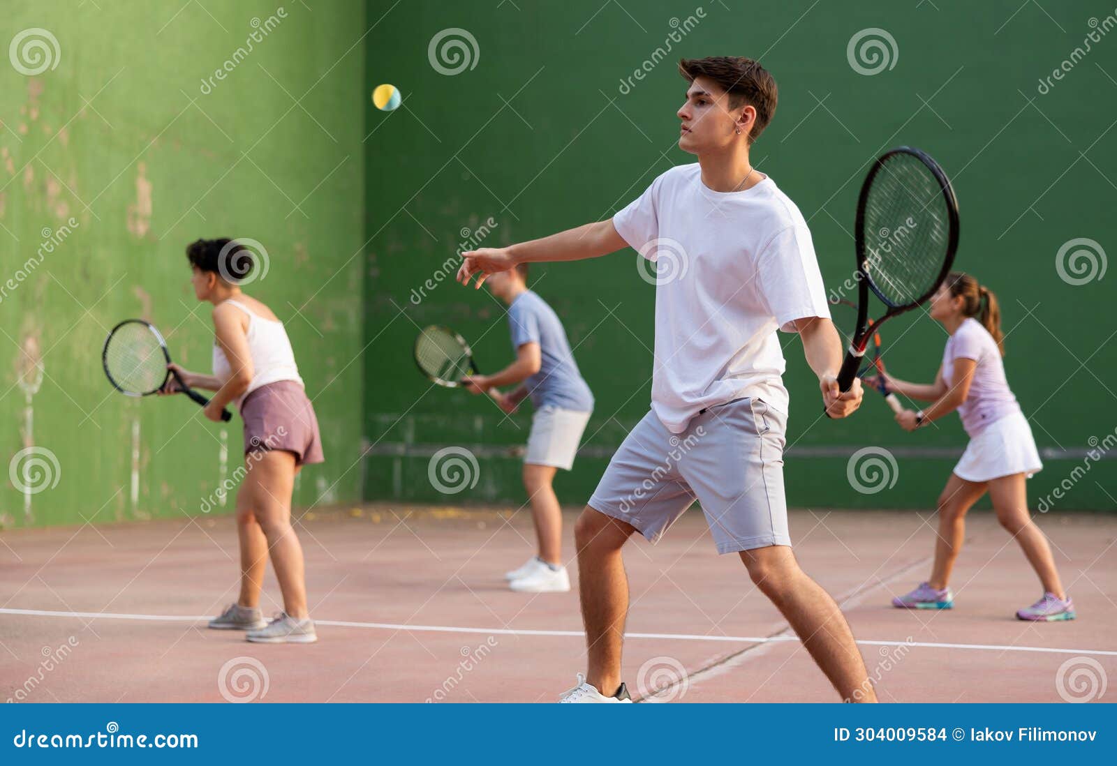 young male pelota player hitting ball with racket