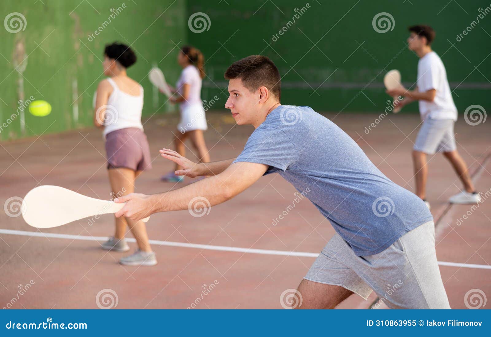 young male pelota player hitting ball with racket