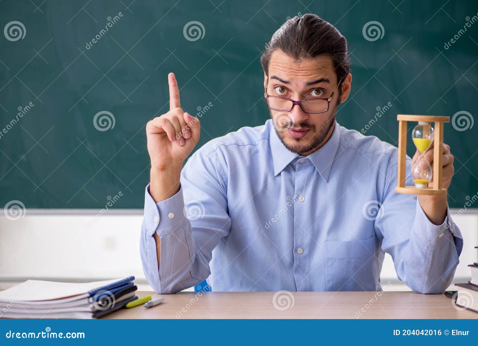 Young Male Teacher in the Classroom in Time Management Concept Stock