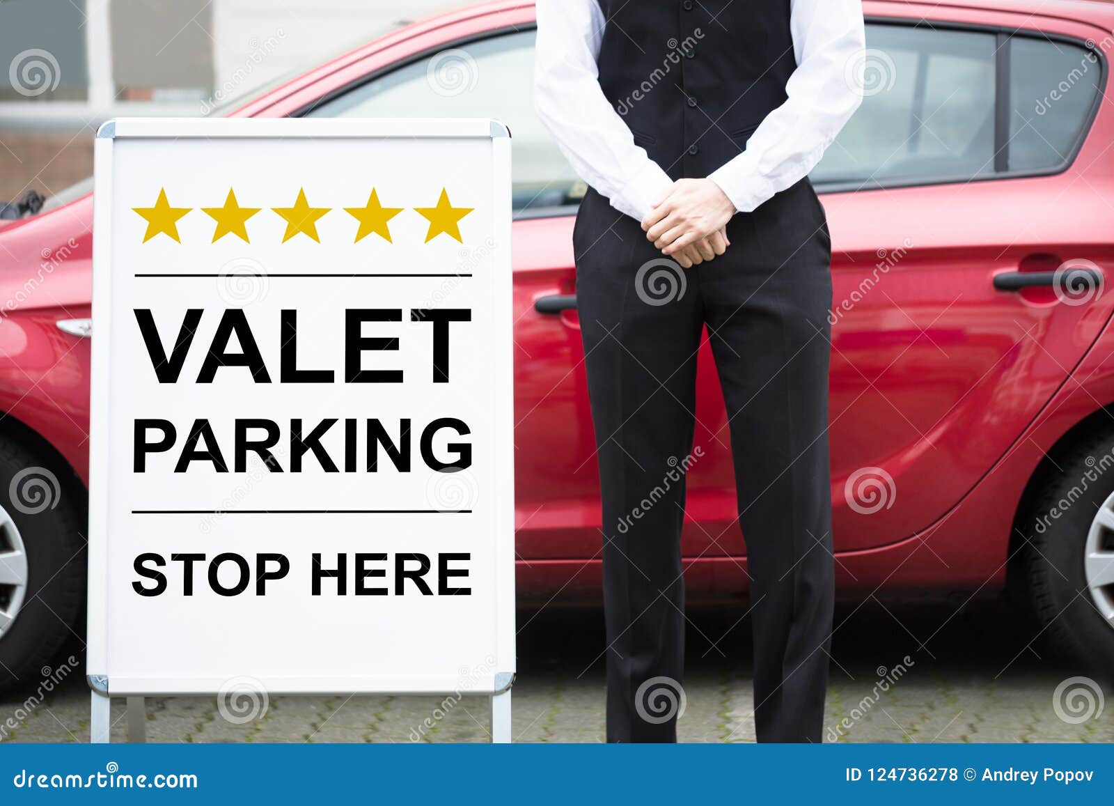 young male valet standing near parking sign close up 124736278