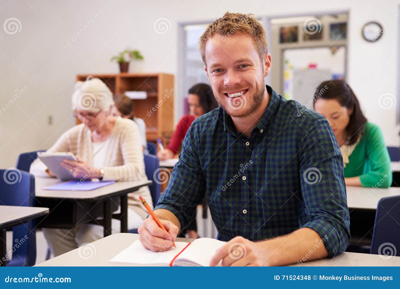 young man at an adult education class looking to camera