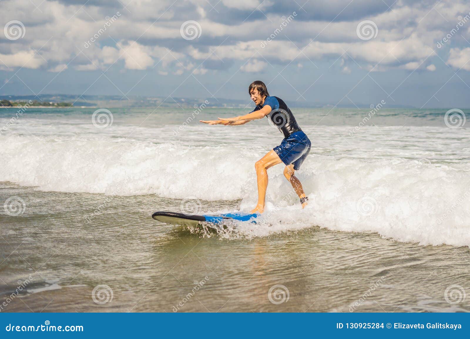 Young Man Beginner Surfer Learns To Surf On A Sea Foam On Young Man Beginner Surfer Learns To Surf On A Sea Foam On