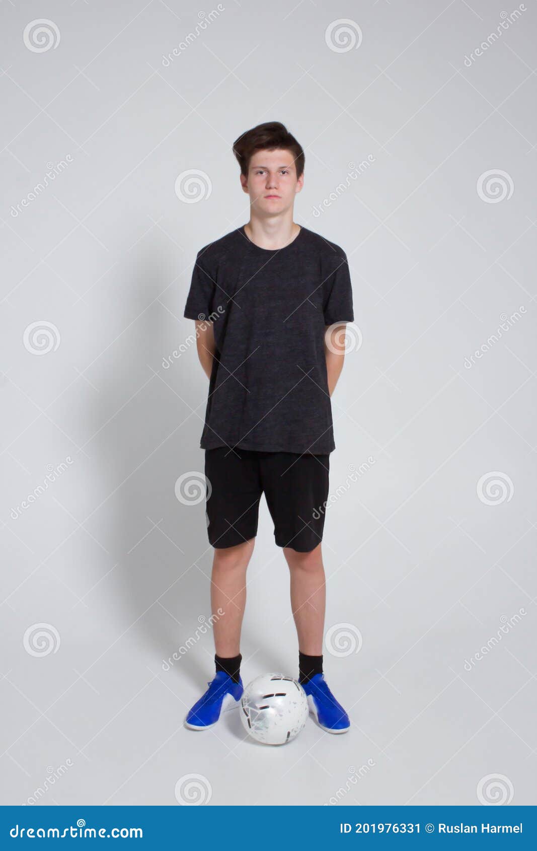 Young Man in Blue Soccer T-Shirt and Black Shorts Standing Beside