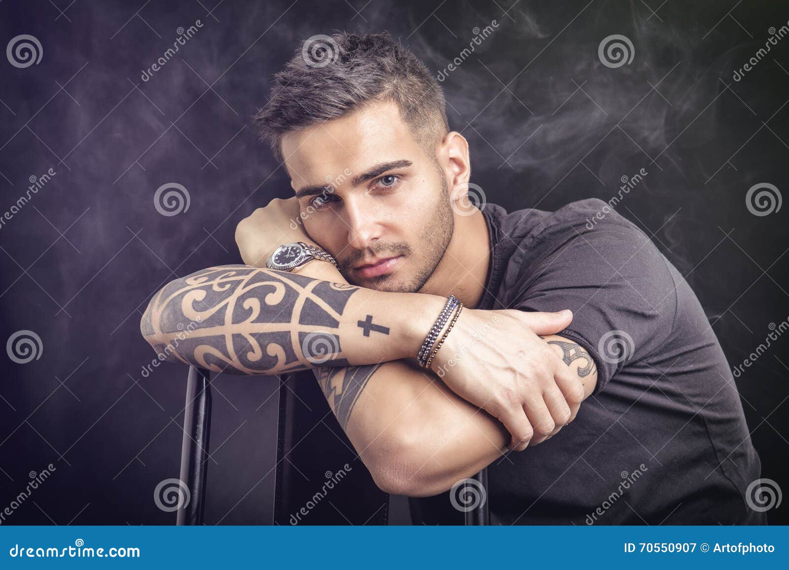 Muscular asian man showing stylish tattoo on arms, wearing green casual t  shirt isolated Stock Photo by msvyatkovska